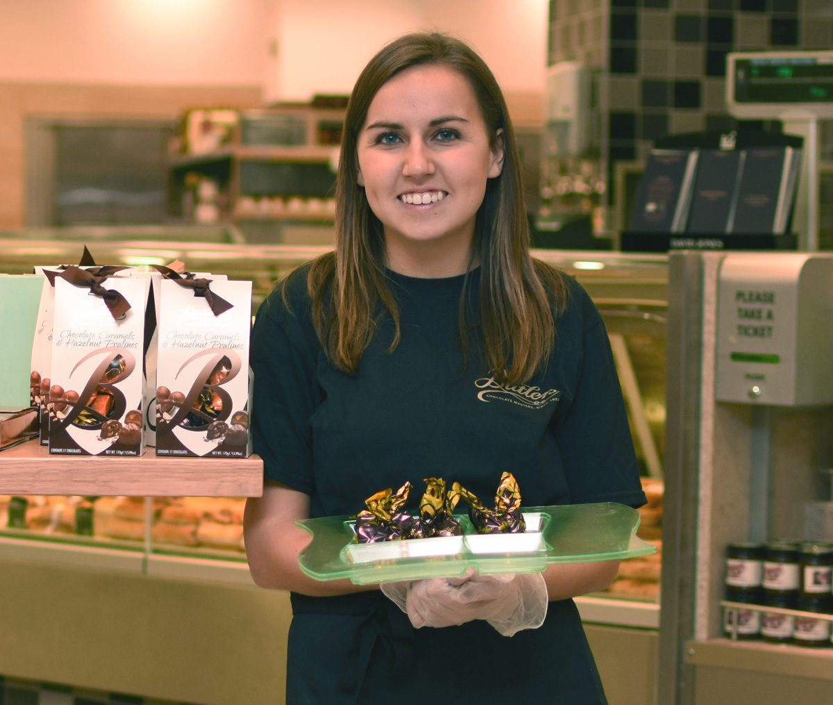 A product demonstrator holding a range of chocolate samples